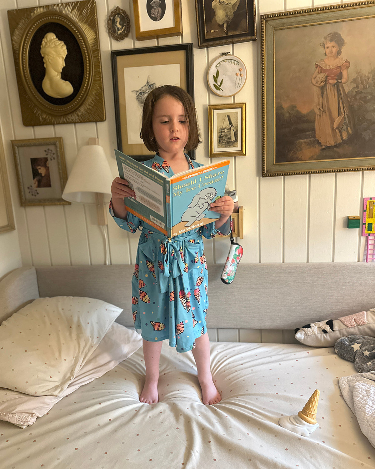 Kid in Ice Cream cone robe reading a book