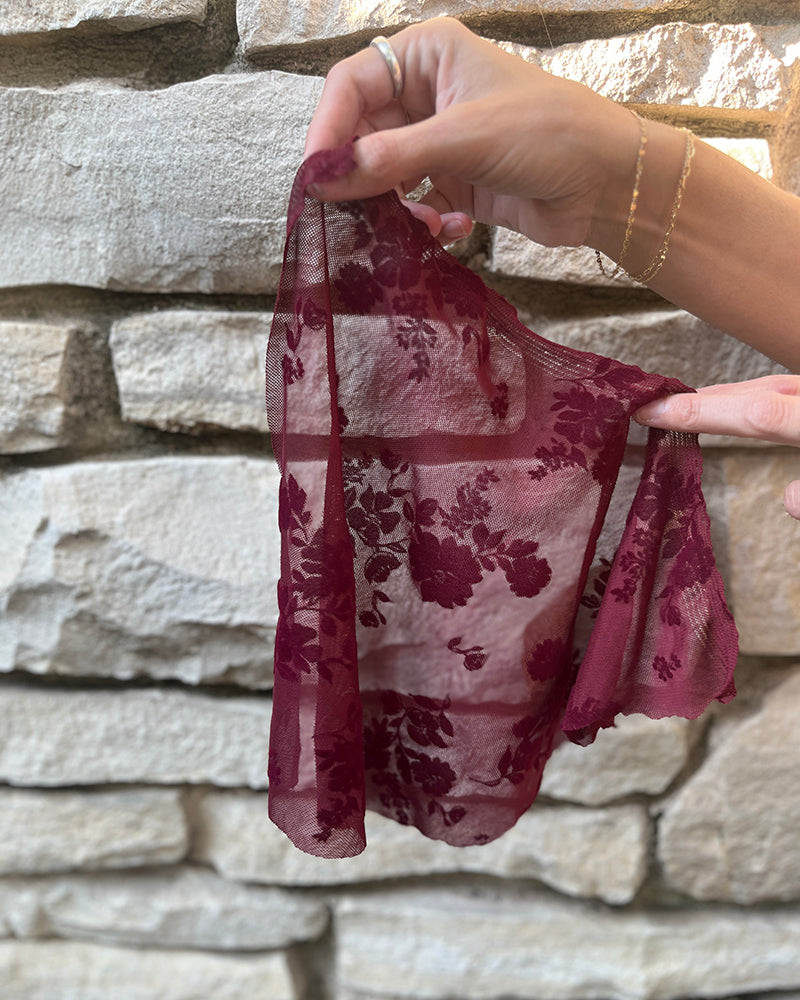 Sheer red fabric against a stone wall