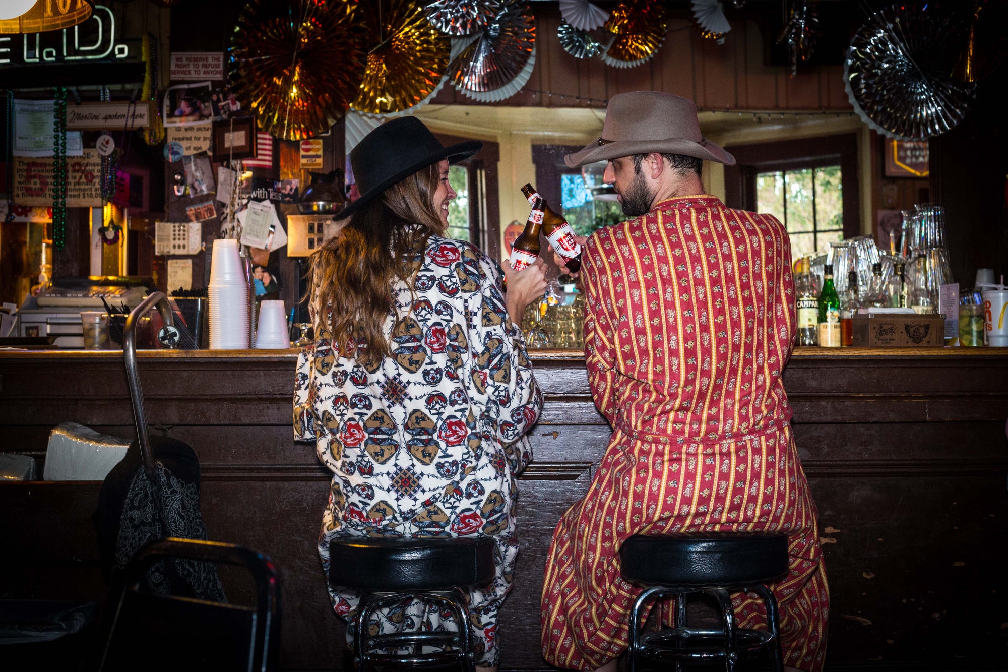 Two people sitting at a bar wearing bathrobes